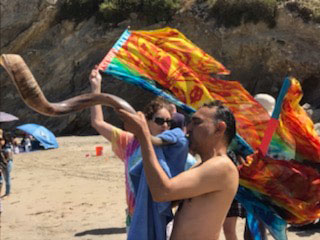 Blowing the shofar at a beach baptism